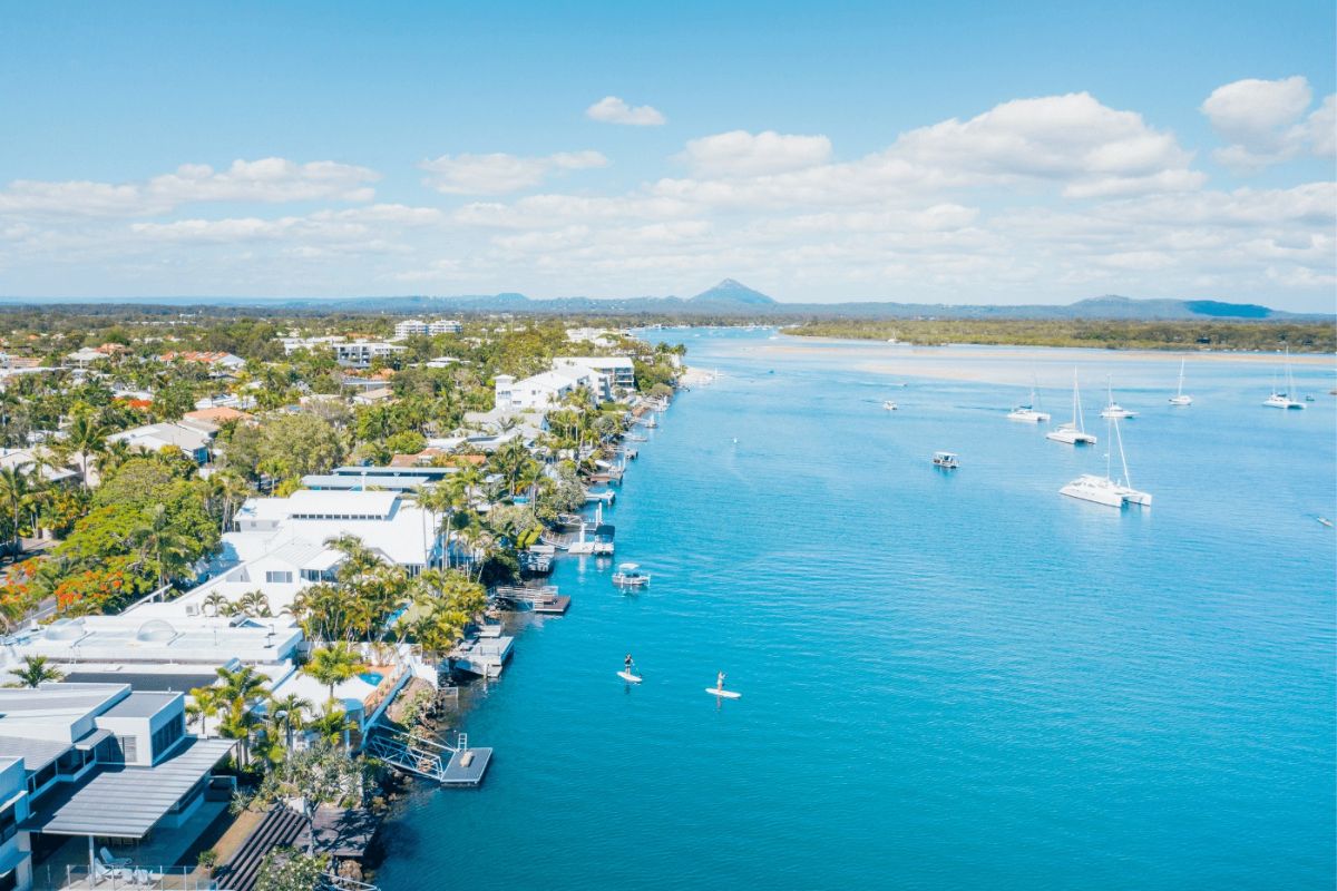 Scenic Noosaville holiday view of the Noosa River with paddleboarders and boats