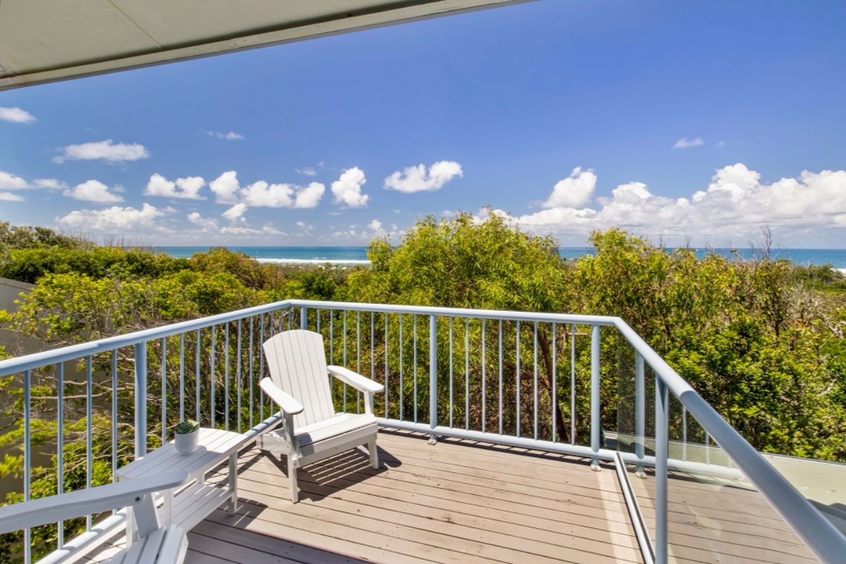 Castaways Beach accommodation balcony with ocean views and coastal greenery